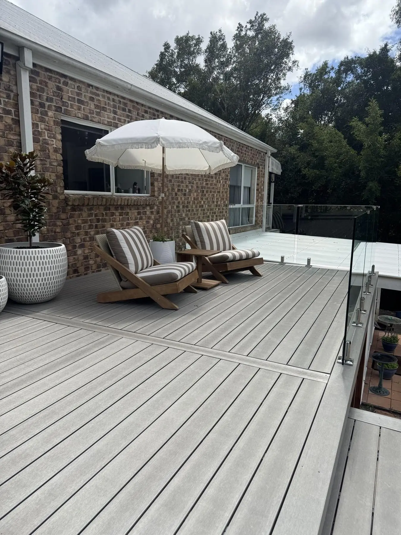 Completed composite deck with outdoor furniture overlooking a pool
