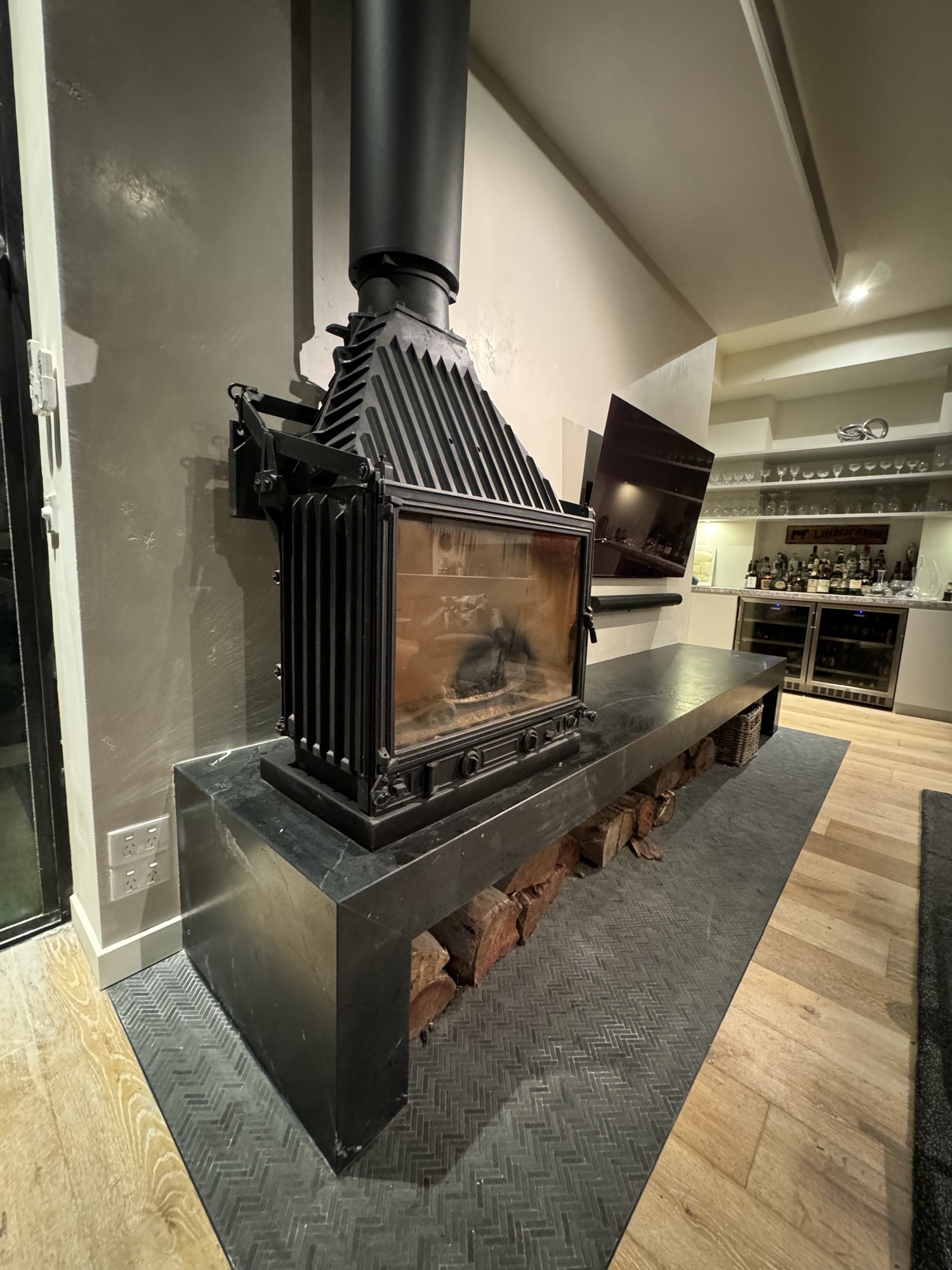 Cast-iron wood heater on black stone plinth