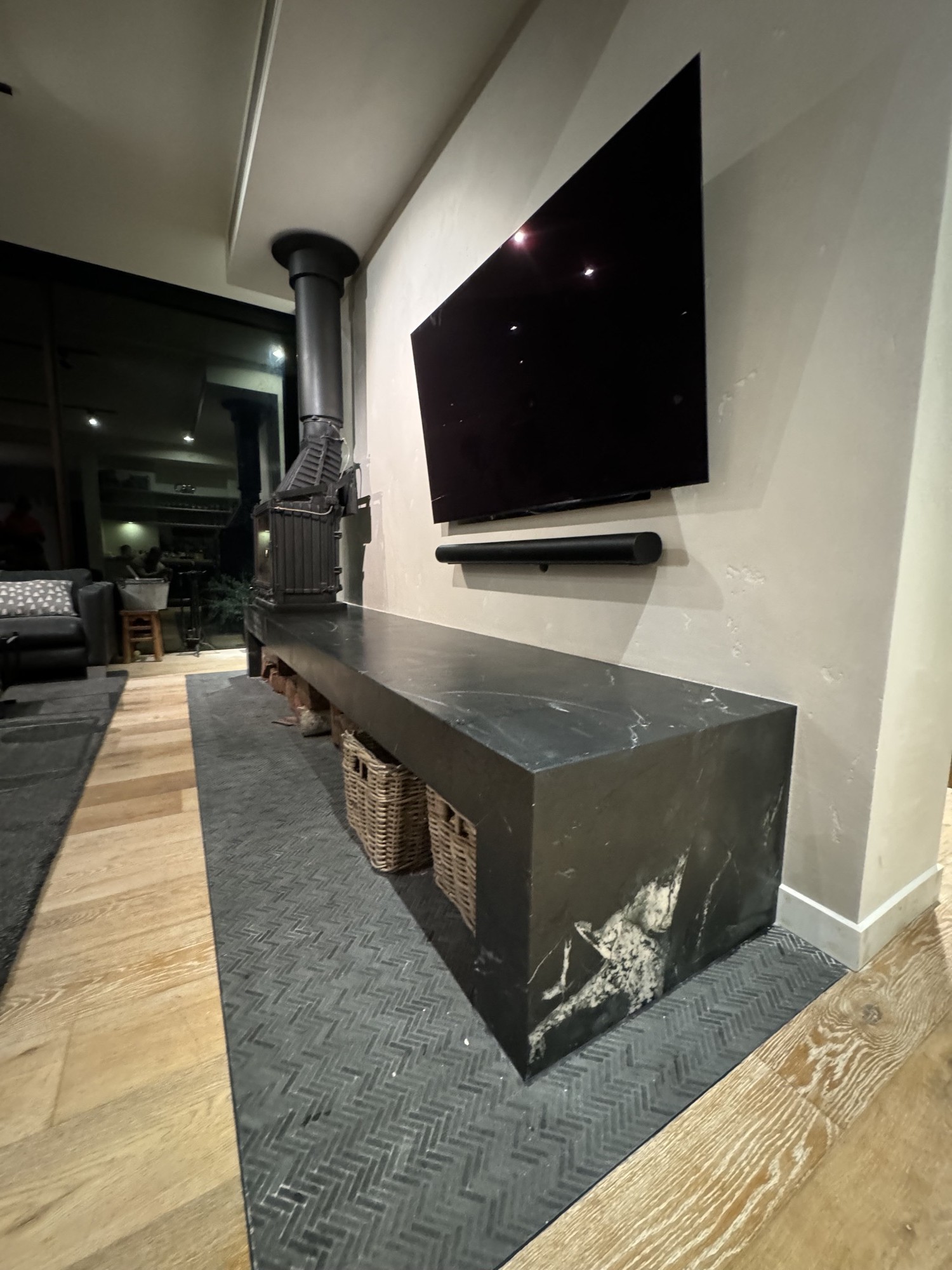 Stone plinth with wall-mounted TV and integrated baskets