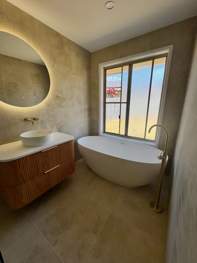 Renovated bathroom with a freestanding bath and fluted timber-look vanity in Regents Park