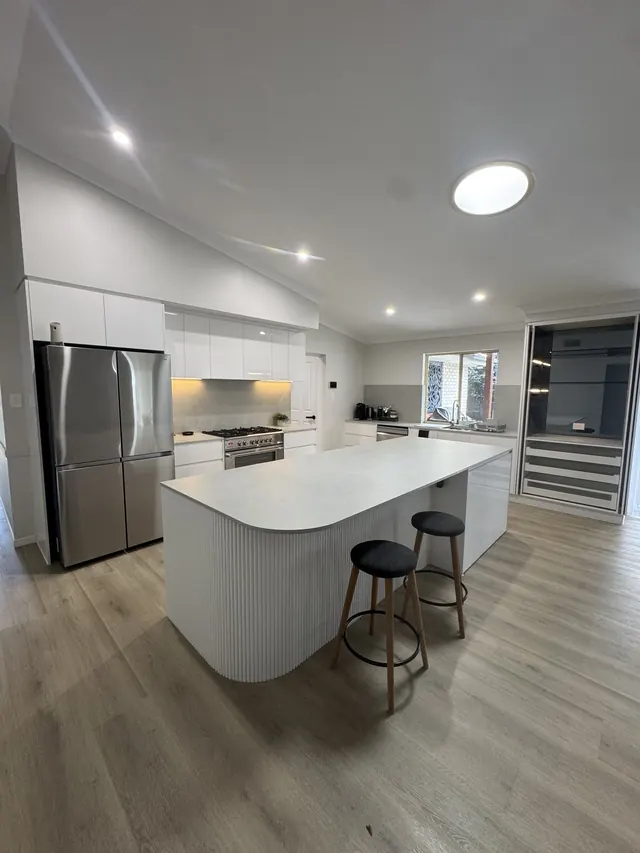 The Wellington Point kitchen, with a curved fluted island and white cabinetry