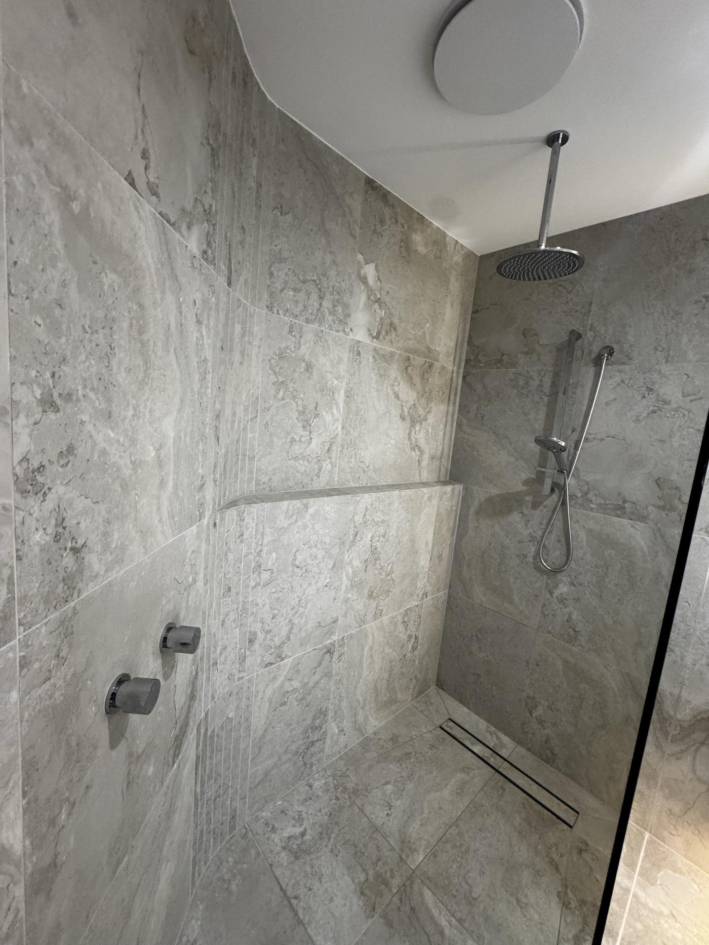 Walk-in shower with rain head and linear floor drain